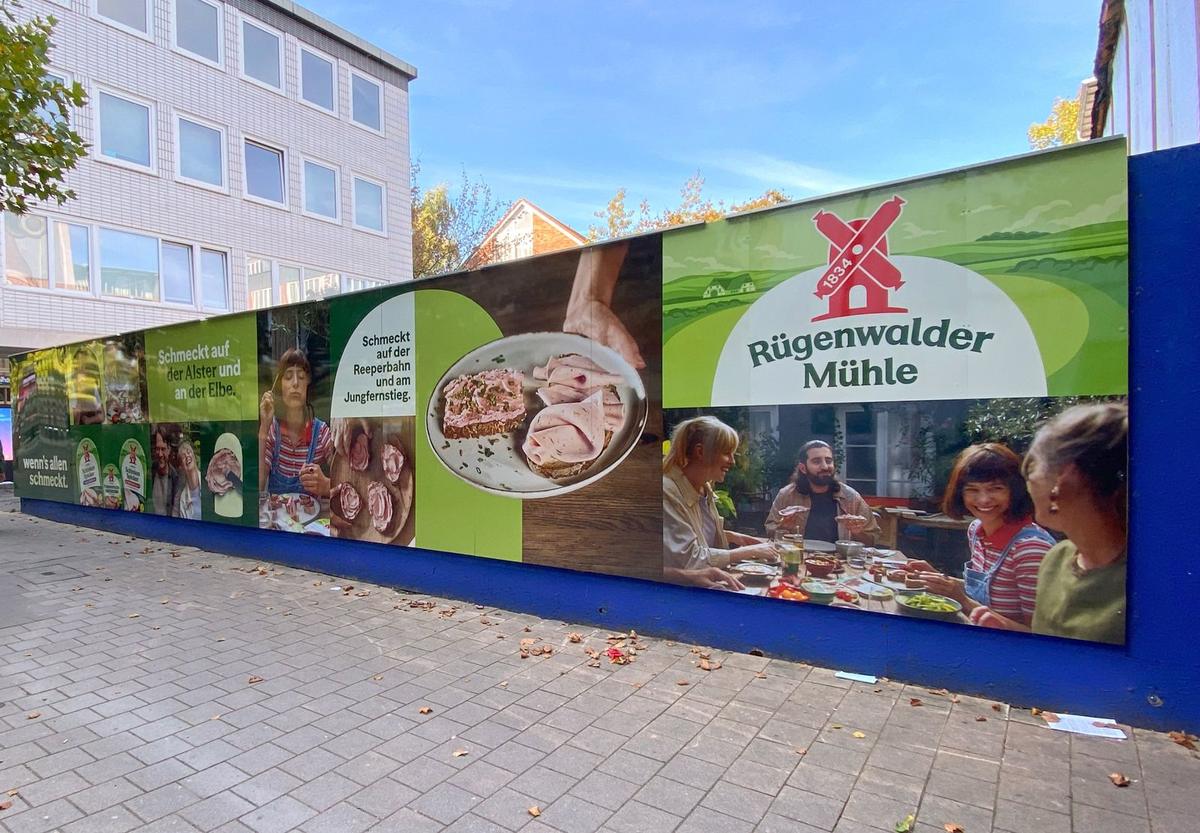 Bauzaun an einer Baustelle mit großformatiger Lebensmittelwerbung